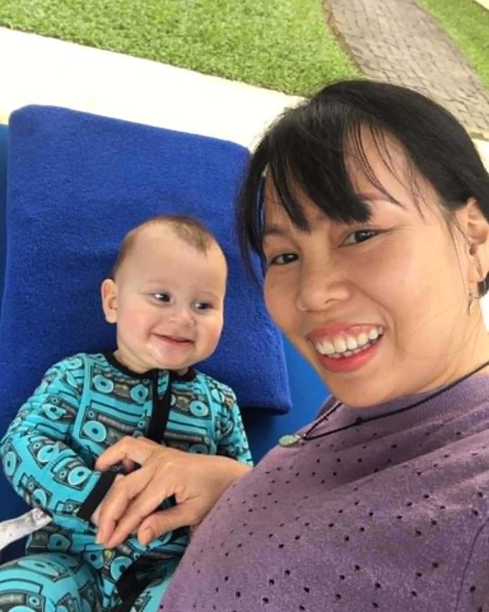 Trang outdoors with a child she cares for in Hoi An